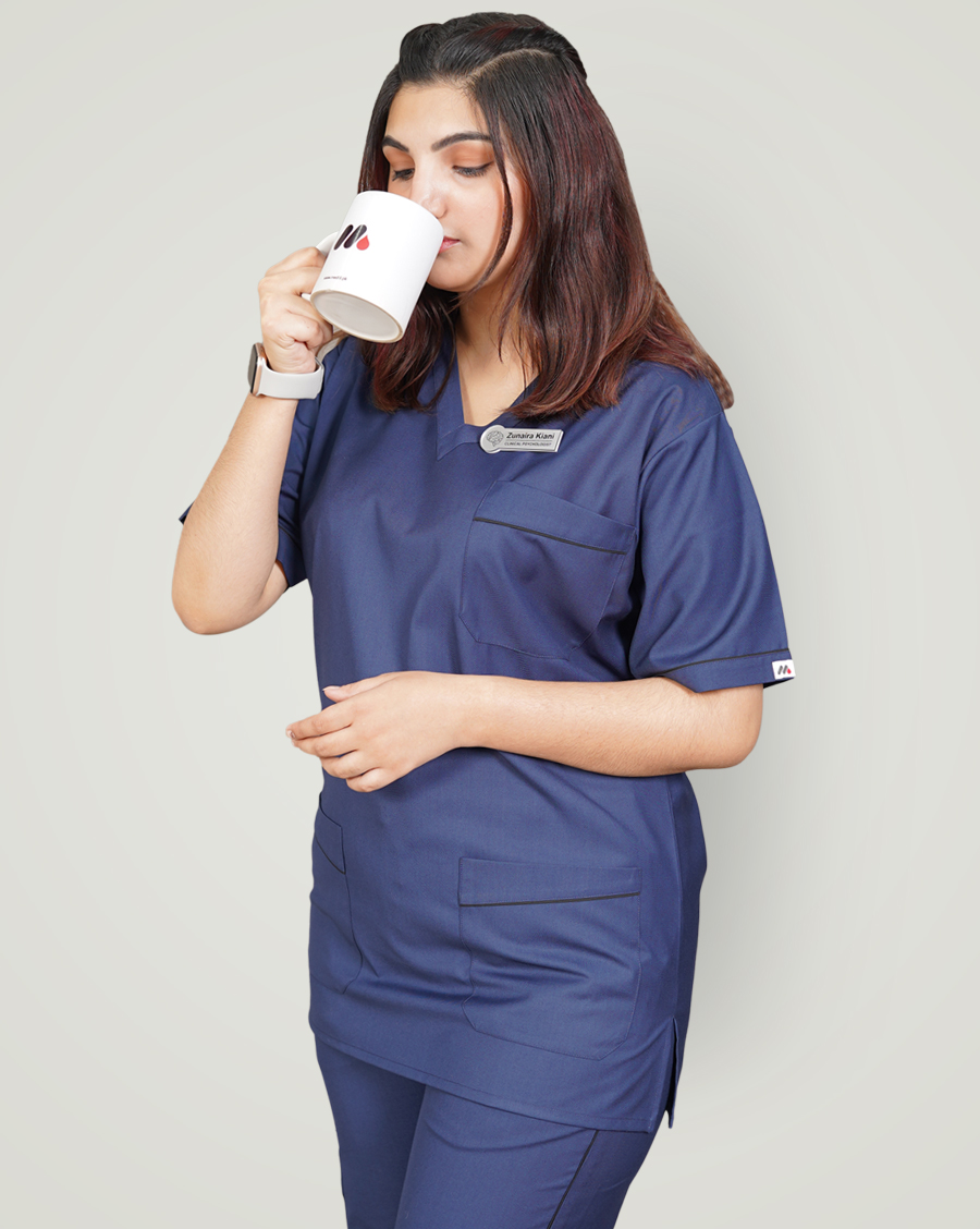 woman wear blue color scrub and drinking tea